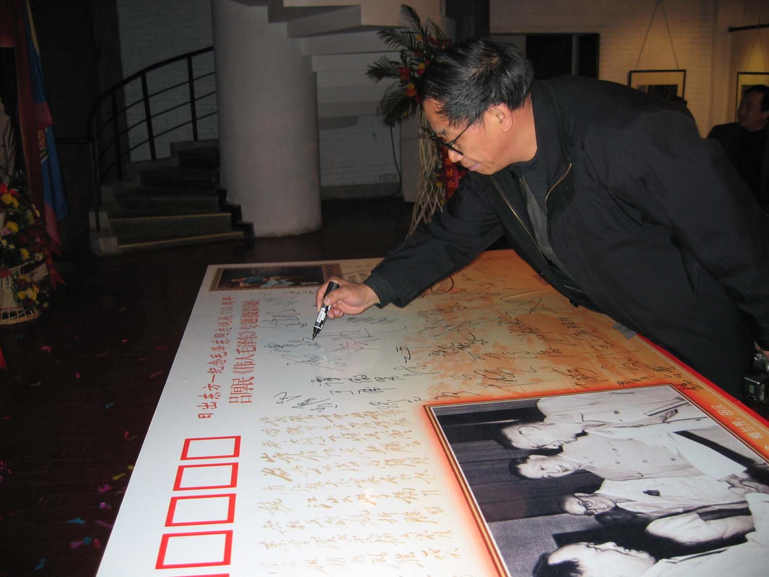 曾毅在纪念封展板上签名留念.jpg