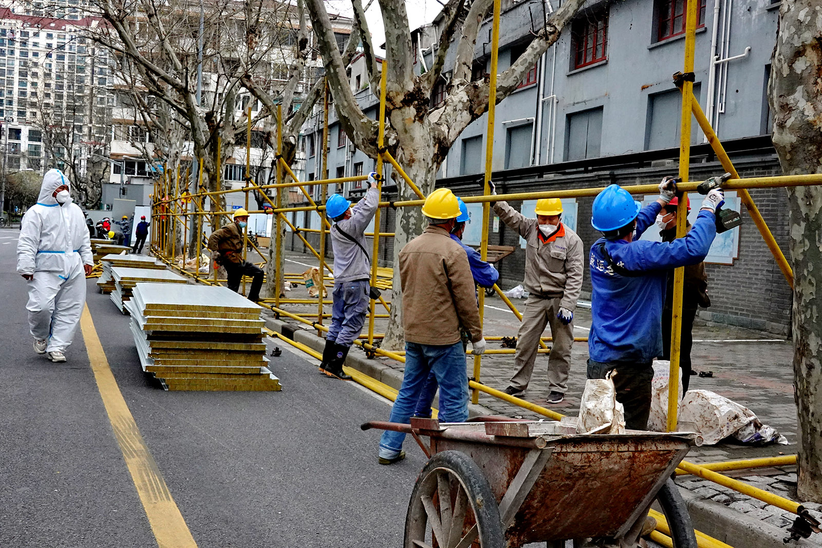 2022年3月19日，顺昌路建国路口附近，工人搭起临时外墙。王定森 图