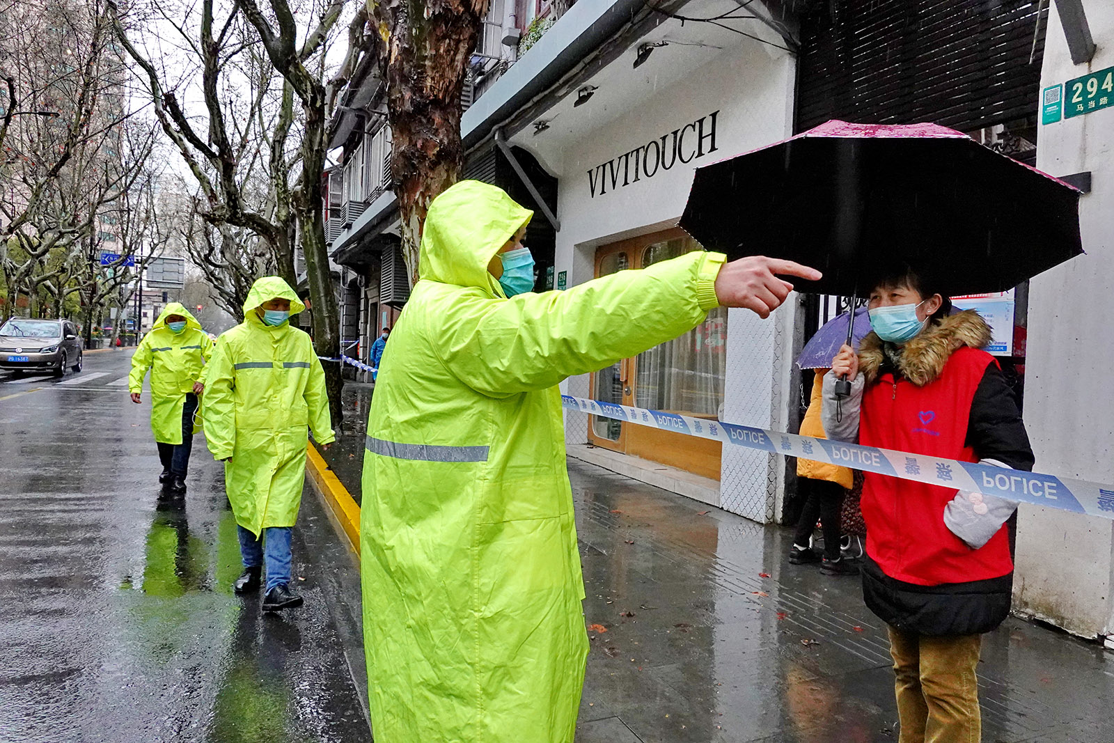 2022年3月21日，身着雨衣的人给帮助当地居民。王定森 图